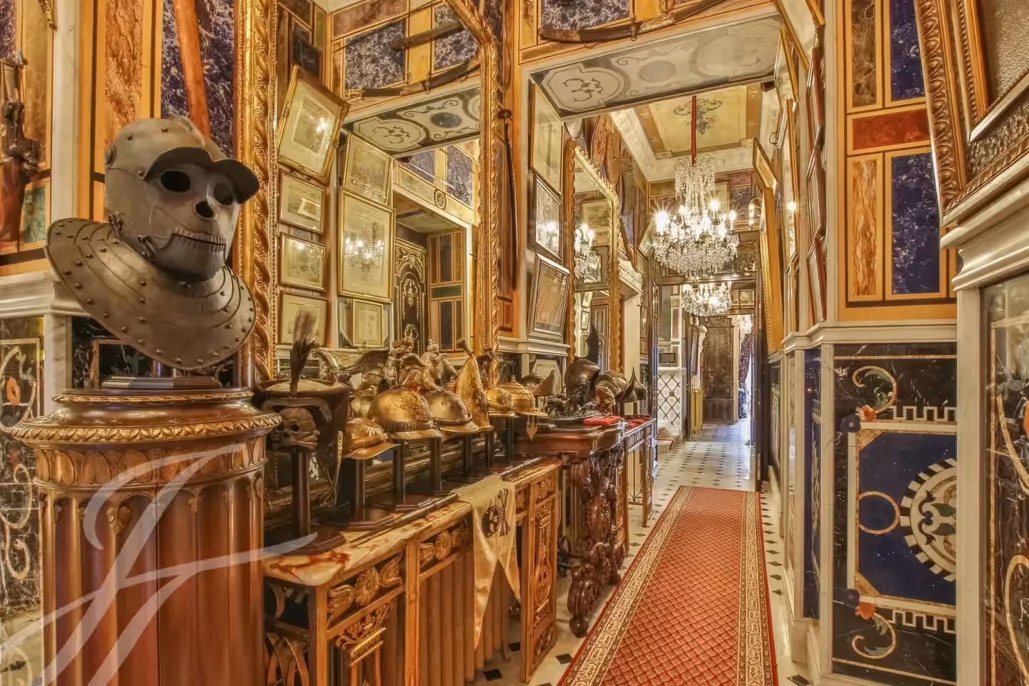 Galleria interna del castello con specchi e sculture.