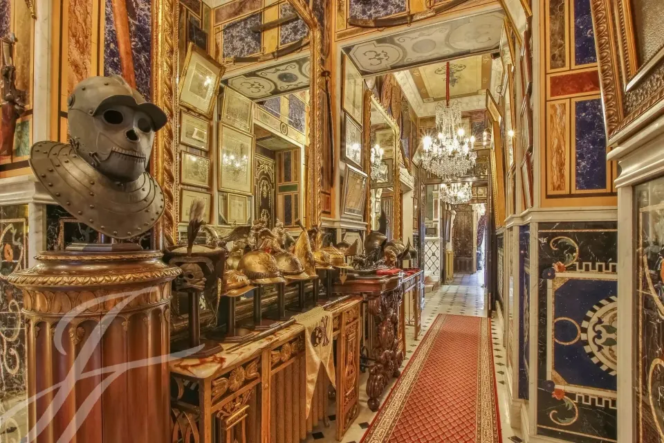 Galleria interna con specchi, sculture e tappeto rosso