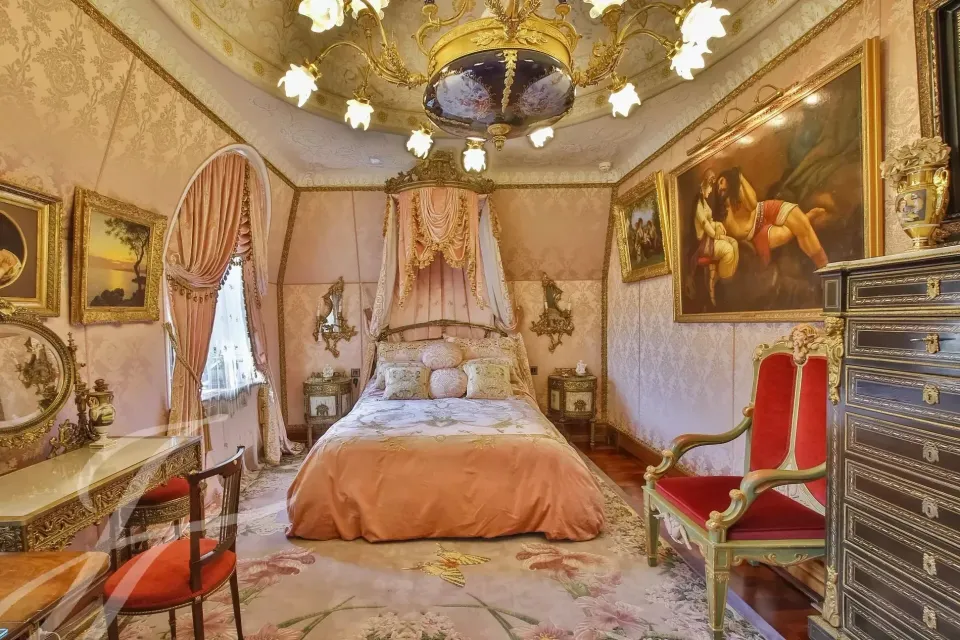 Camera da letto con letto a baldacchino chiaro e dipinti