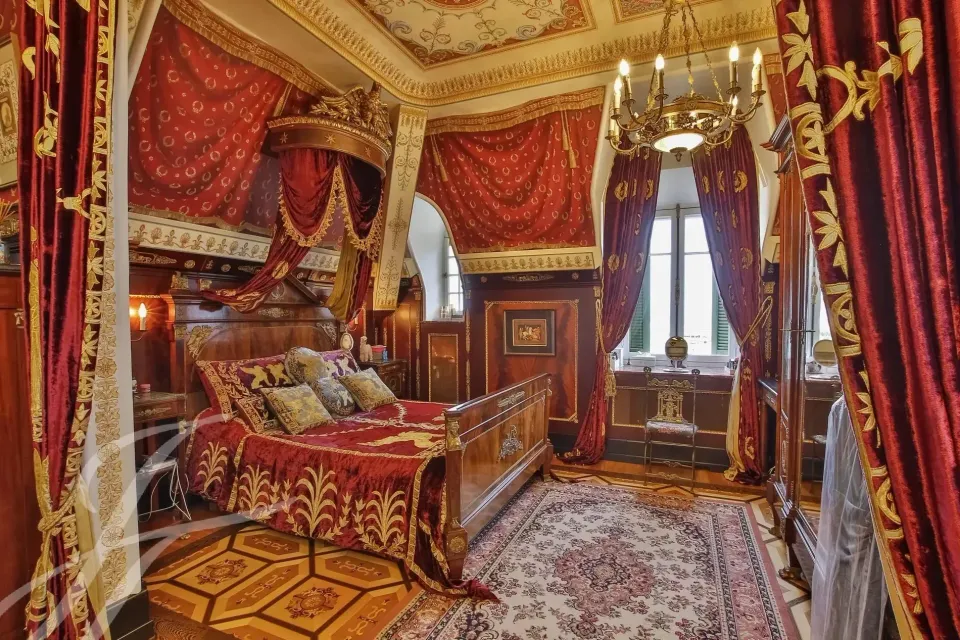 Camera da letto con tessuti rossi e finiture dorate