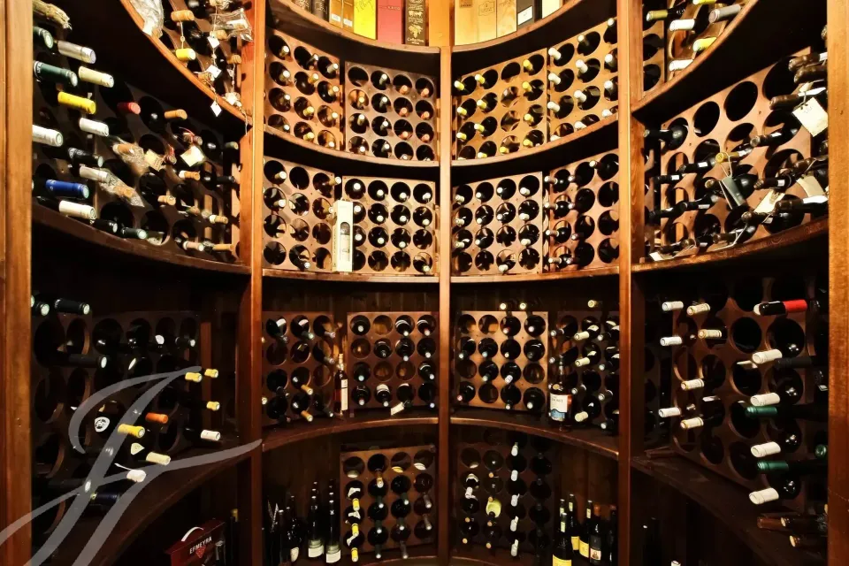 Cantina con bottiglie di vino su scaffalature curve